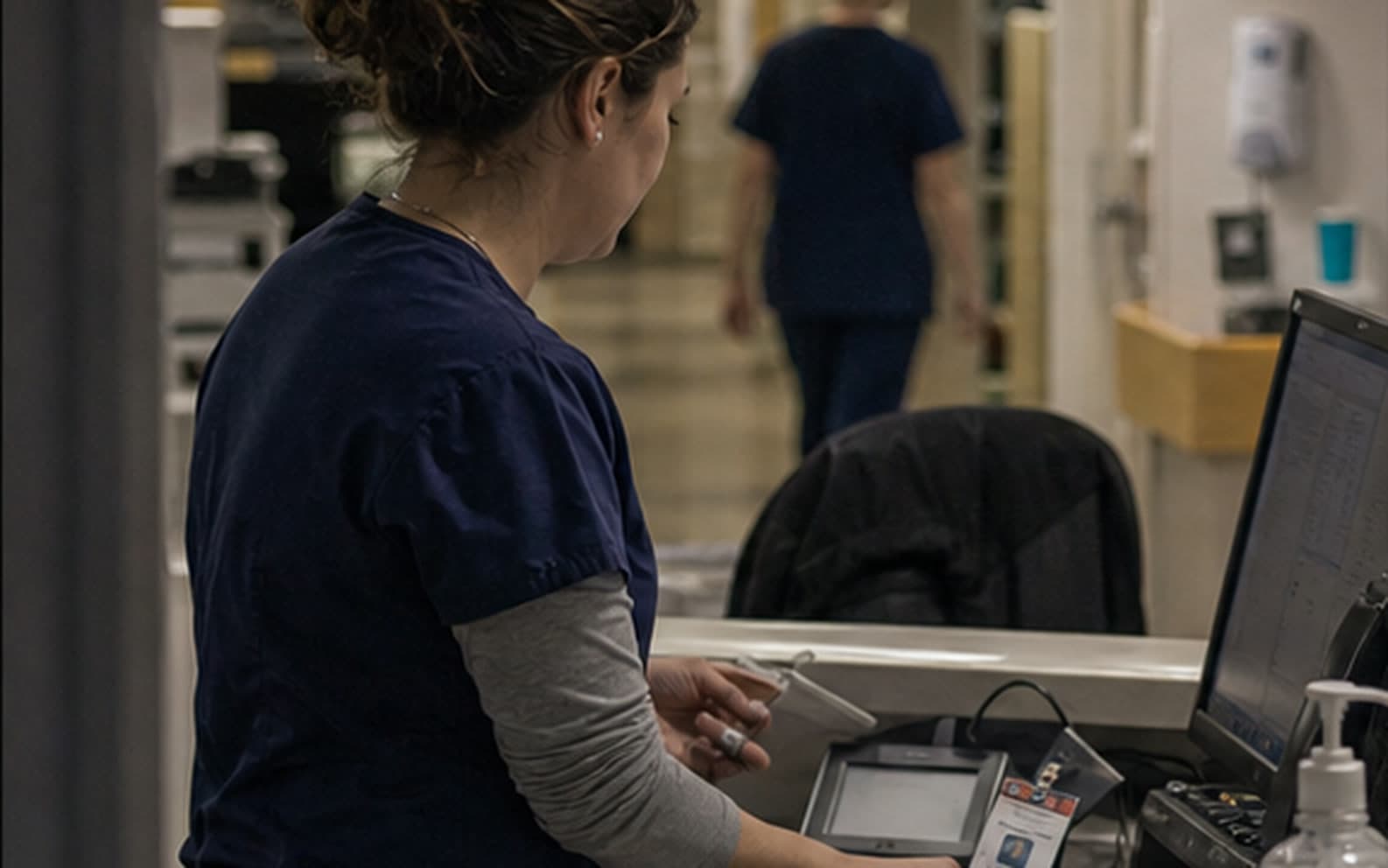 A healthcare professional working at a hospital workstation